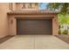 Attached two-car garage with brown door and concrete driveway at 15289 W Valentine St, Surprise, AZ 85379