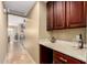 Hallway view with beverage station with dark wood cabinets and granite countertops at 15289 W Valentine St, Surprise, AZ 85379