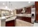 Spacious kitchen featuring tile floors, dark wood cabinets, granite countertops, stainless steel appliances, and recessed lighting at 15289 W Valentine St, Surprise, AZ 85379