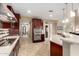 Bright kitchen featuring tile flooring, dark wood cabinets, granite countertops, and stainless steel appliances at 15289 W Valentine St, Surprise, AZ 85379