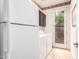 This laundry room features tile floors, a refrigerator, and a door to the outside at 15289 W Valentine St, Surprise, AZ 85379