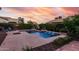 Sparkling backyard pool with fountains and concrete pavers under a gorgeous colorful sky at dusk at 15289 W Valentine St, Surprise, AZ 85379