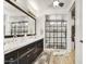 Bathroom with double vanity and walk-in shower featuring black grid-style glass at 16987 W Princeton Ave, Goodyear, AZ 85395