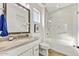 Bathroom features a vanity with a beige countertop and a shower-tub with a glass door at 16987 W Princeton Ave, Goodyear, AZ 85395