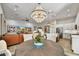 Open dining area with wood table beneath a crystal chandelier, flowing to the kitchen and living room at 16987 W Princeton Ave, Goodyear, AZ 85395