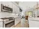 Modern kitchen featuring stainless steel appliances, white cabinets, subway tile backsplash, and hardwood floors at 16987 W Princeton Ave, Goodyear, AZ 85395