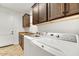 Laundry room with wood cabinets, a sink, and a modern washer and dryer at 16987 W Princeton Ave, Goodyear, AZ 85395