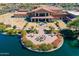 Stunning aerial view of the community clubhouse, pond and outdoor seating areas of the Cantamia neighborhood at 18182 W Glenhaven Dr, Goodyear, AZ 85338