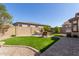 Backyard with artificial turf, brick walkways, and an outdoor seating area and grill at 18182 W Glenhaven Dr, Goodyear, AZ 85338