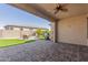 Covered backyard patio area with brick pavers, an outdoor grill, and a cozy seating area at 18182 W Glenhaven Dr, Goodyear, AZ 85338