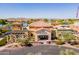 Aerial view of the Cantamia Model Home Center with a lake and desert landscaping in the background at 18182 W Glenhaven Dr, Goodyear, AZ 85338