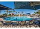 Sparkling community pool surrounded by palm trees and lounge chairs, perfect for relaxation and recreation at 18182 W Glenhaven Dr, Goodyear, AZ 85338