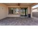 Covered patio with brick flooring, fan, and a sliding glass door leading to the interior at 18182 W Glenhaven Dr, Goodyear, AZ 85338