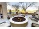 Inviting outdoor firepit area with comfortable seating for residents, surrounded by mature desert landscaping at 18182 W Glenhaven Dr, Goodyear, AZ 85338