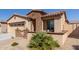 Inviting home exterior featuring a stone accent wall, low landscaping, and a walkway leading to the front entrance at 18182 W Glenhaven Dr, Goodyear, AZ 85338