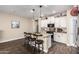 This kitchen features a center island with barstool seating, white cabinets, and stainless steel appliances at 18182 W Glenhaven Dr, Goodyear, AZ 85338