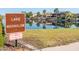 Lake Moonglow sign with lush green space and a view of homes in the background at 18182 W Glenhaven Dr, Goodyear, AZ 85338