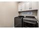 Laundry room features modern washer and dryer, white cabinets, and a decorative 'Laundry Co.' sign at 18182 W Glenhaven Dr, Goodyear, AZ 85338