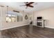 Spacious living room featuring a stone fireplace, wood-look flooring, and large windows providing natural light at 18182 W Glenhaven Dr, Goodyear, AZ 85338