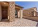 Charming covered patio with stone accents and neutral colored pavers, perfect for outdoor seating at 18182 W Glenhaven Dr, Goodyear, AZ 85338