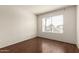 Bright bedroom featuring wood floors and a window showcasing a palm tree at 2035 S Elm St # 218, Tempe, AZ 85282