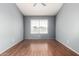 Empty bedroom featuring hardwood floors, light blue walls, and window at 2035 S Elm St # 218, Tempe, AZ 85282