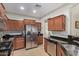 Spacious kitchen with stainless steel appliances, dark wood cabinets, and granite countertops at 20512 N 260Th Ln, Buckeye, AZ 85396