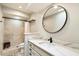 Updated bathroom featuring a stone shower, stylish vanity and sleek, round mirror at 25515 N Forest N Rd # 2, Rio Verde, AZ 85263