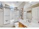 Bright bathroom with a shower-tub combo, oak vanity, and decorative artwork at 26560 N 115Th St, Scottsdale, AZ 85255