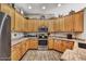 Bright kitchen with wood cabinets, stainless steel appliances, and laminate floors, offering a clean and functional cooking space at 26560 N 115Th St, Scottsdale, AZ 85255