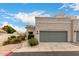 Charming single story home featuring a gray garage door, stone landscaping, and a sidewalk at 295 N Rural Rd # 151, Chandler, AZ 85226