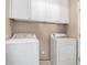 Bright laundry room featuring a washer, dryer, and storage cabinets at 295 N Rural Rd # 151, Chandler, AZ 85226