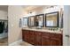 Elegant primary bathroom with granite countertops, double sinks, dark wood cabinetry, and large mirrors at 3020 E Rockledge Rd, Phoenix, AZ 85048