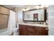 Bathroom featuring a double vanity with granite countertops, and tiled shower/tub and shuttered window at 3020 E Rockledge Rd, Phoenix, AZ 85048