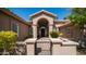 Charming close up of covered entryway with arched columns and decorative black metal gate to a quaint front yard at 3020 E Rockledge Rd, Phoenix, AZ 85048