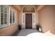 Elegant entryway with decorative dark wood door, sidelights, transom window, and stylish black planters at 3020 E Rockledge Rd, Phoenix, AZ 85048