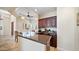 Well-appointed kitchen featuring dark wood cabinets, granite countertops, breakfast bar, and a bright dining area at 3020 E Rockledge Rd, Phoenix, AZ 85048