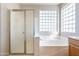 Bathroom showcasing a shower, soaking tub and a glass block window providing natural light at 3524 E Derringer Way, Gilbert, AZ 85297