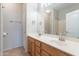 Bathroom featuring a dual sink vanity with wood cabinets and a large mirror reflecting the shower/tub combo at 3524 E Derringer Way, Gilbert, AZ 85297