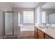 Well-lit bathroom with glass block window, featuring a shower over tub and single vanity, offering a spa-like experience at 3524 E Derringer Way, Gilbert, AZ 85297