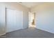 Carpeted bedroom with bi-fold closet doors and an open doorway to the en suite bathroom at 3524 E Derringer Way, Gilbert, AZ 85297