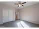 Cozy carpeted bedroom with large closet space and a ceiling fan, creating a comfortable and inviting atmosphere at 3524 E Derringer Way, Gilbert, AZ 85297