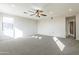 Large, carpeted bonus room with a ceiling fan, multiple windows, and doorway to the en suite at 3524 E Derringer Way, Gilbert, AZ 85297