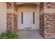 Close-up of the welcoming front door, framed by stone accents and a neutral color palette at 3524 E Derringer Way, Gilbert, AZ 85297