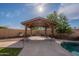 A backyard gazebo with an outdoor kitchen area sits by the pool on a sunny day at 3524 E Derringer Way, Gilbert, AZ 85297