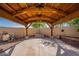 A backyard gazebo with an outdoor kitchen area sits by the pool on a sunny day at 3524 E Derringer Way, Gilbert, AZ 85297