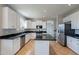 Modern kitchen with white cabinets, stainless steel appliances, and black countertops at 3524 E Derringer Way, Gilbert, AZ 85297