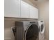 Laundry room featuring a washing machine, dryer, and white cabinets at 3524 E Derringer Way, Gilbert, AZ 85297