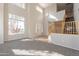 Light-filled living room with large windows, staircase, and neutral carpeting at 3524 E Derringer Way, Gilbert, AZ 85297