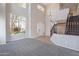 Bright, open-concept living room with large windows, staircase, and chandelier at 3524 E Derringer Way, Gilbert, AZ 85297